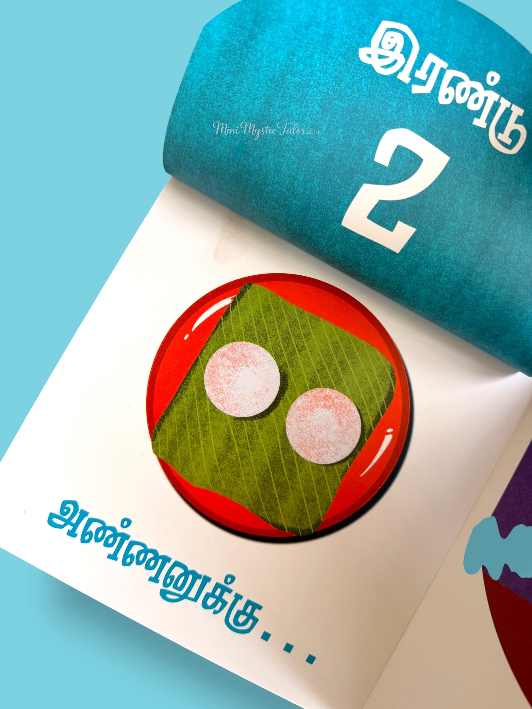 Illustrated Tamil flap book page showing two idlis on a banana leaf for number learning and food recognition