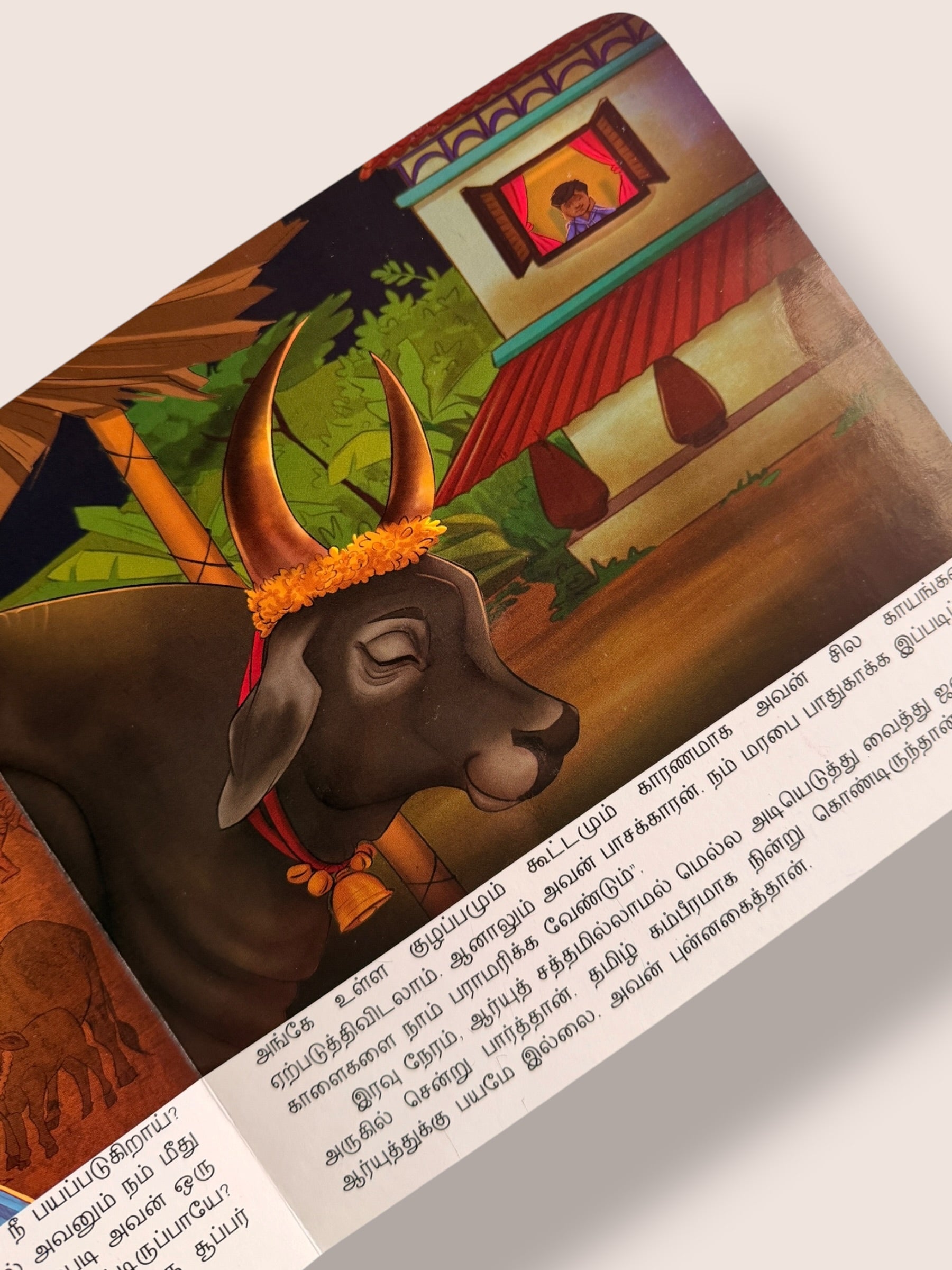 Illustrated page from Tamizhoda Jallikattu children’s book featuring a decorated village bull near a traditional Tamil home - tamil kids book