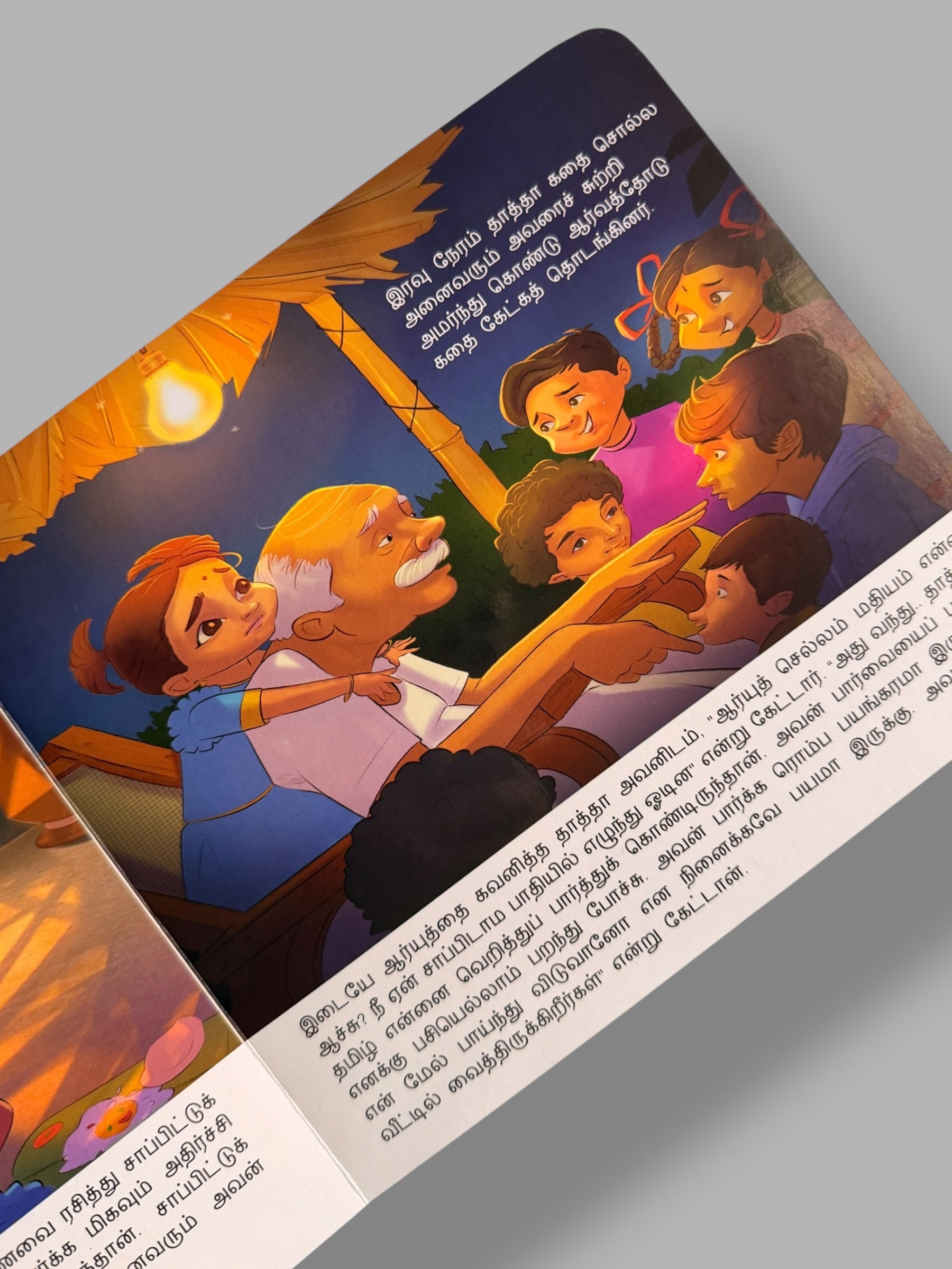 Illustrated page from Tamizhoda Jallikattu story book showing a grandfather telling stories to children in a village at night