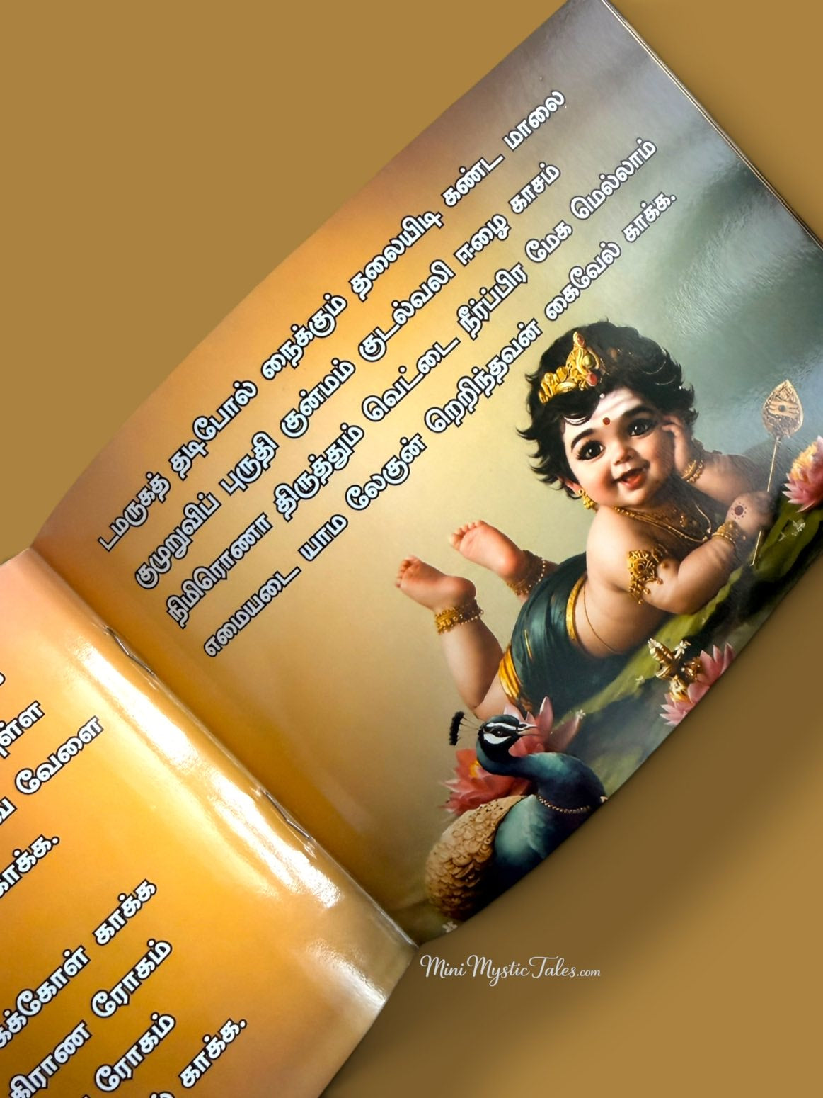 Baby Lord Murugan with Vel and peacock featured inside Shanmuga Kavasam, a Tamil devotional book for Murugan devotees.