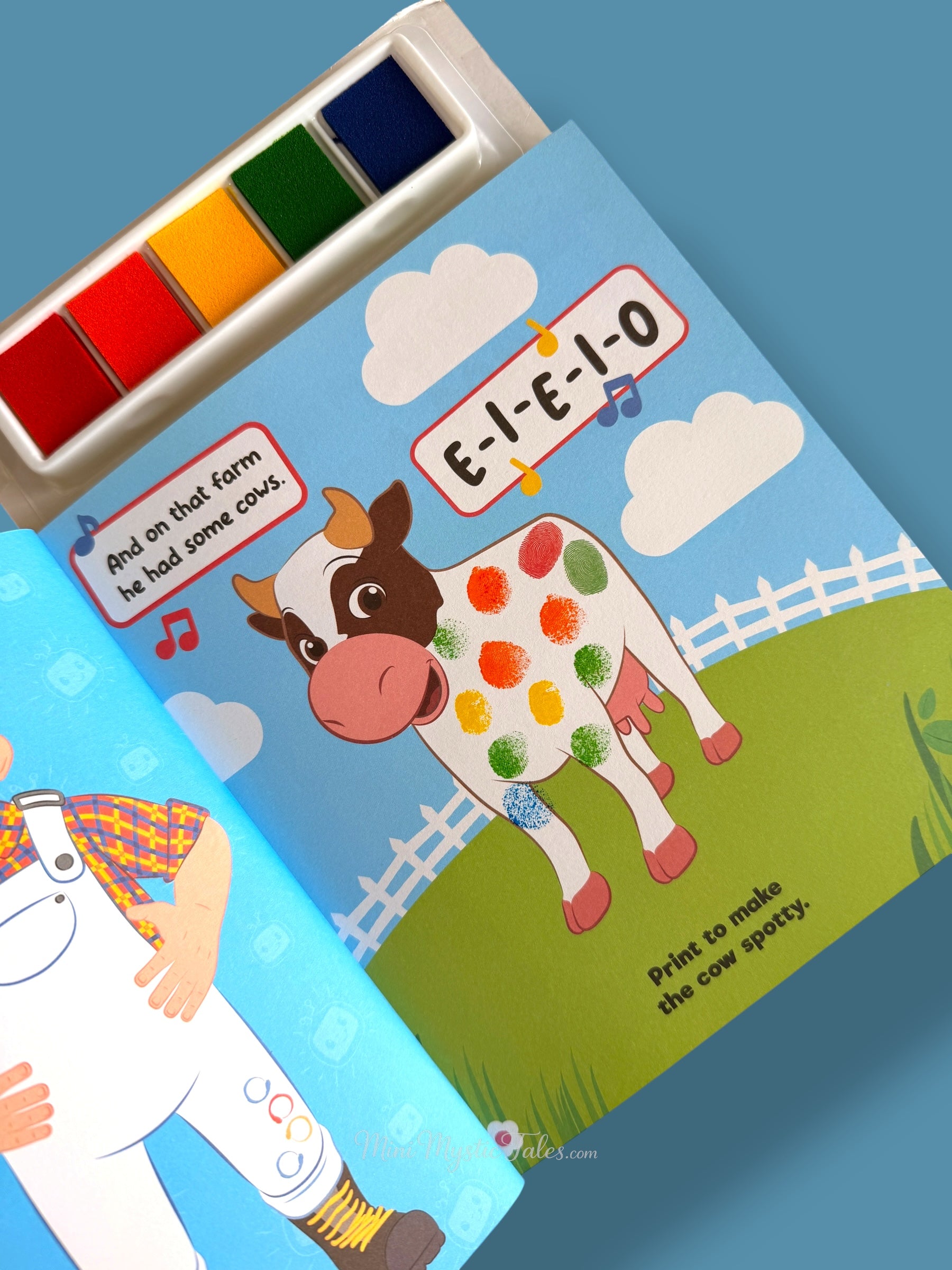 Completed Cocomelon fingerprint cow activity page with colourful fingerprint spots