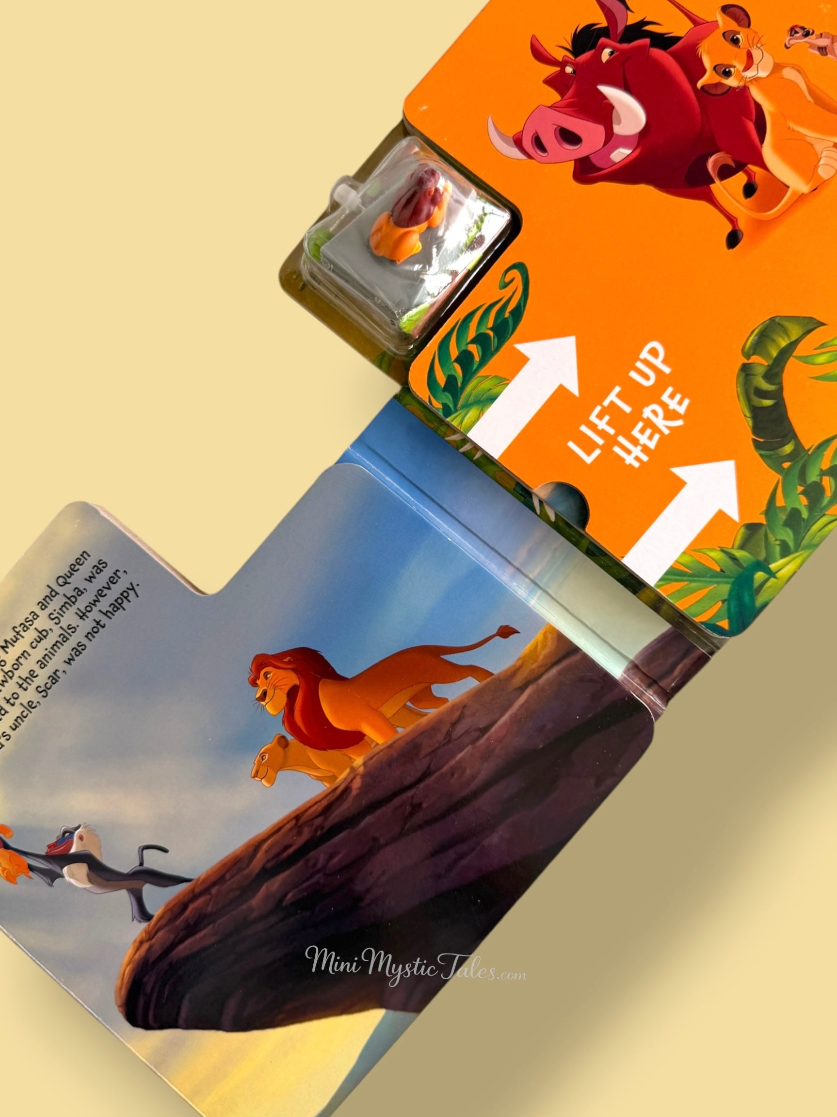 Lion King storybook page featuring Simba, Mufasa, and Rafiki at Pride Rock with interactive wind-up toy compartment