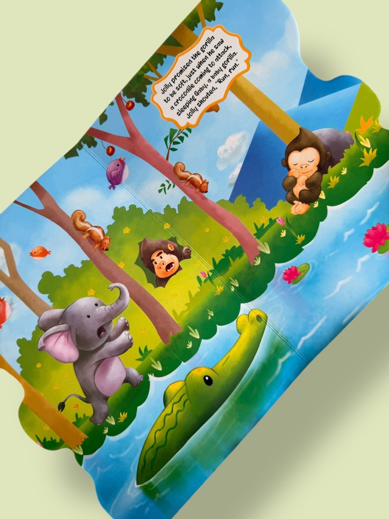 Jolly the Mischievous Elephant Story Board Book page where Jolly’s loud noise wakes a baby gorilla and attracts a crocodile