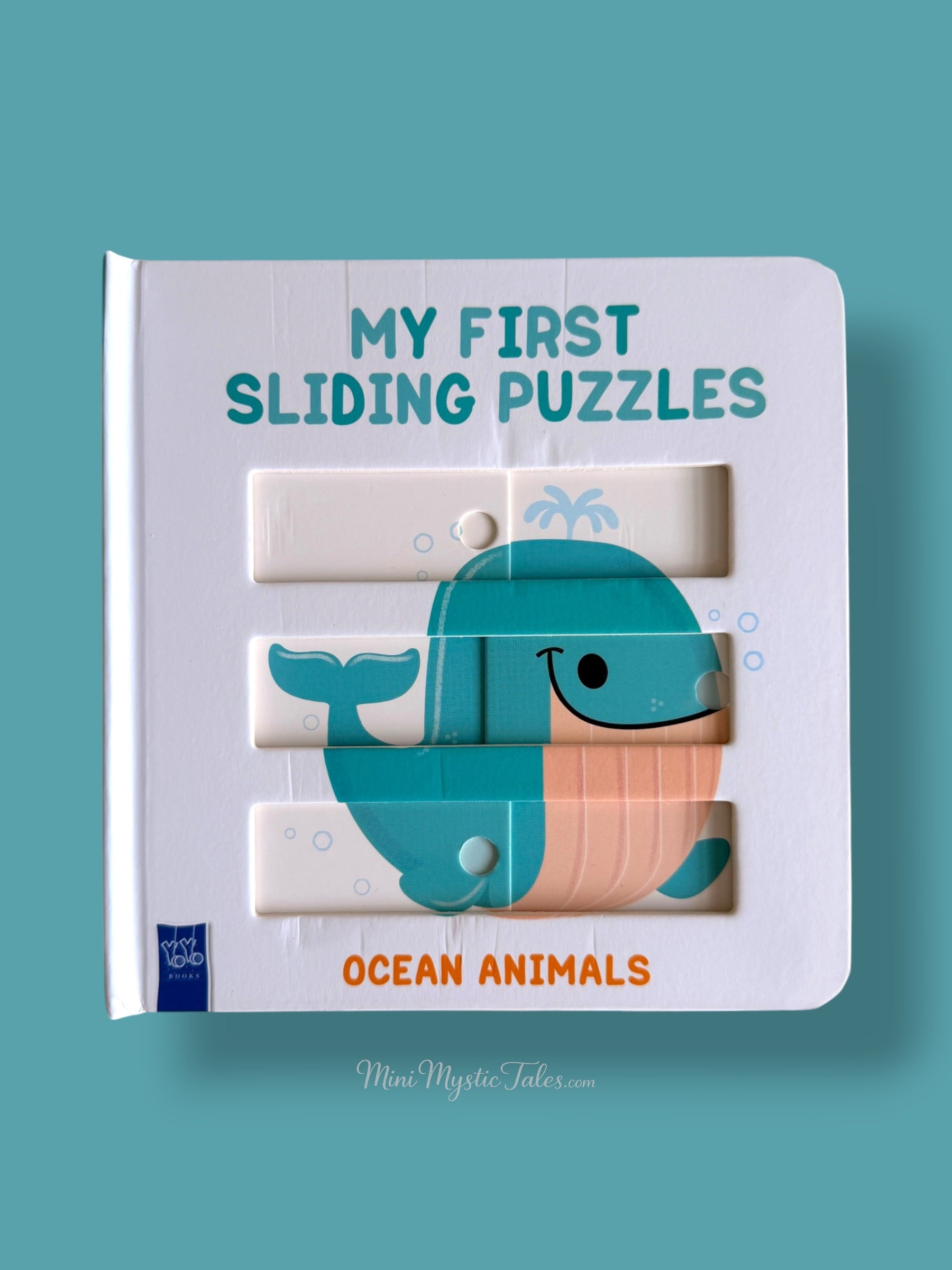 Completed whale sliding puzzle on the cover of an interactive ocean animals board book for young children