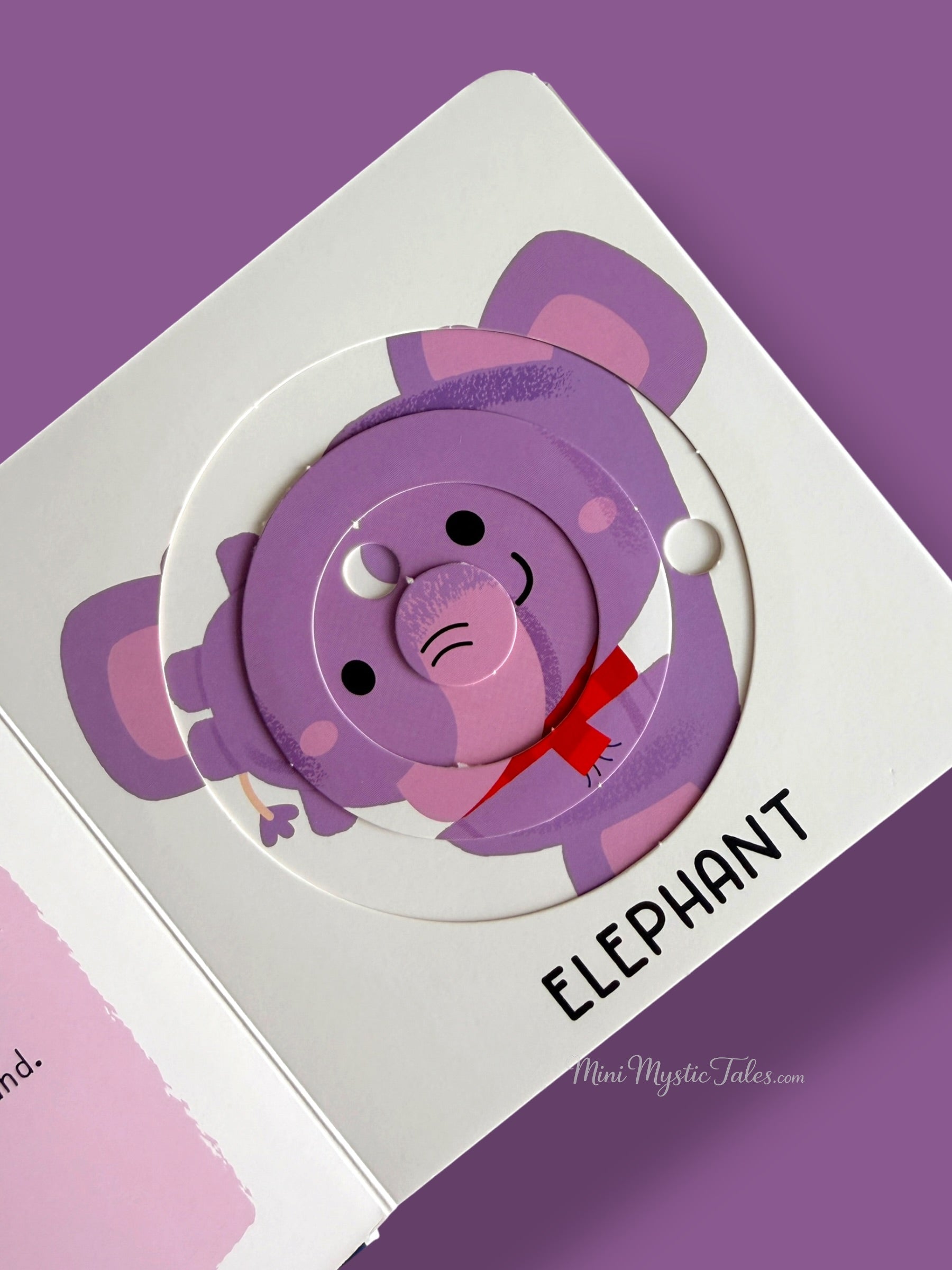 Elephant-themed rotating puzzle activity inside a toddler learning book about wild animals