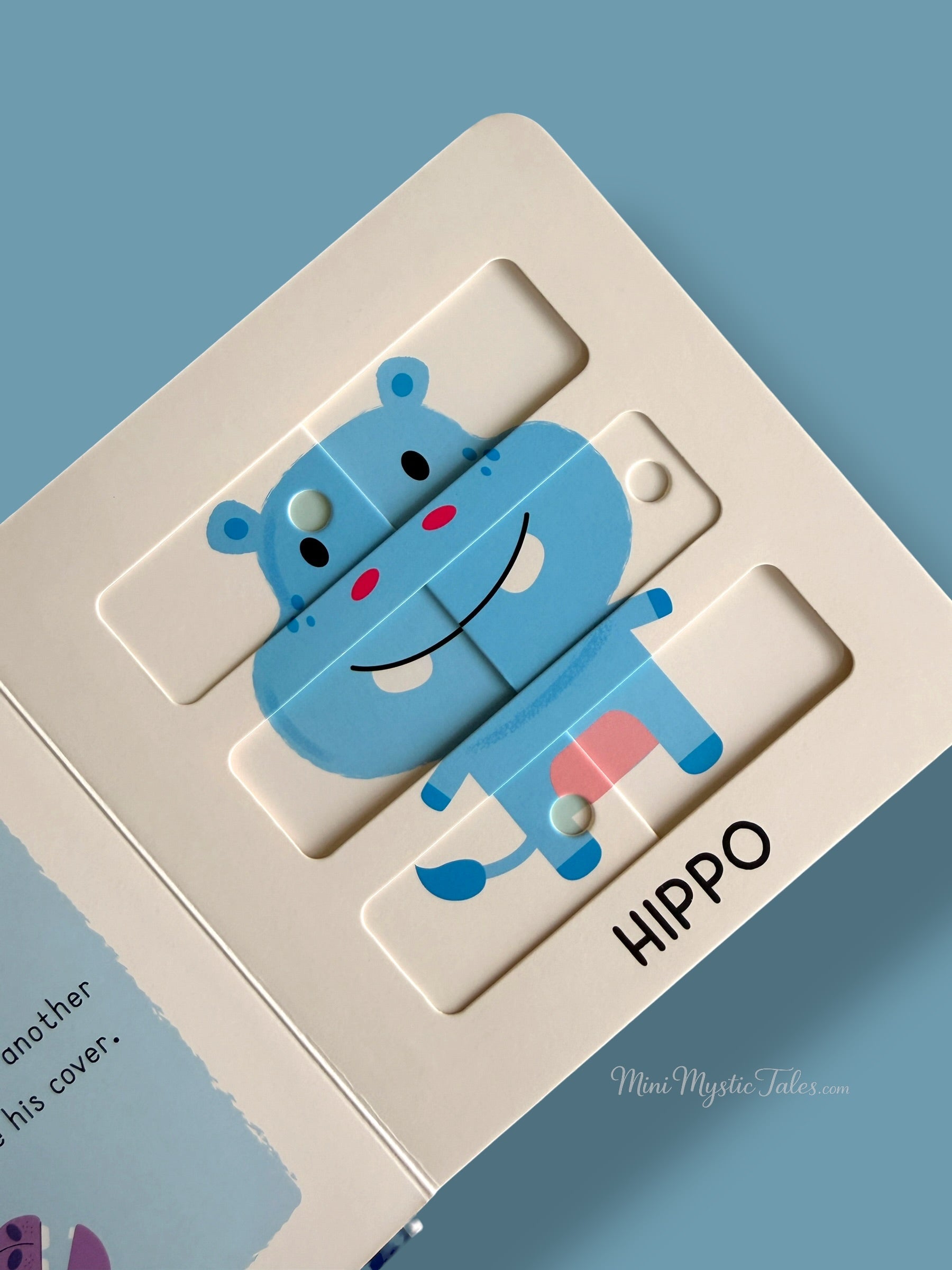 Completed hippo sliding puzzle inside an interactive wild animals board book for toddlers