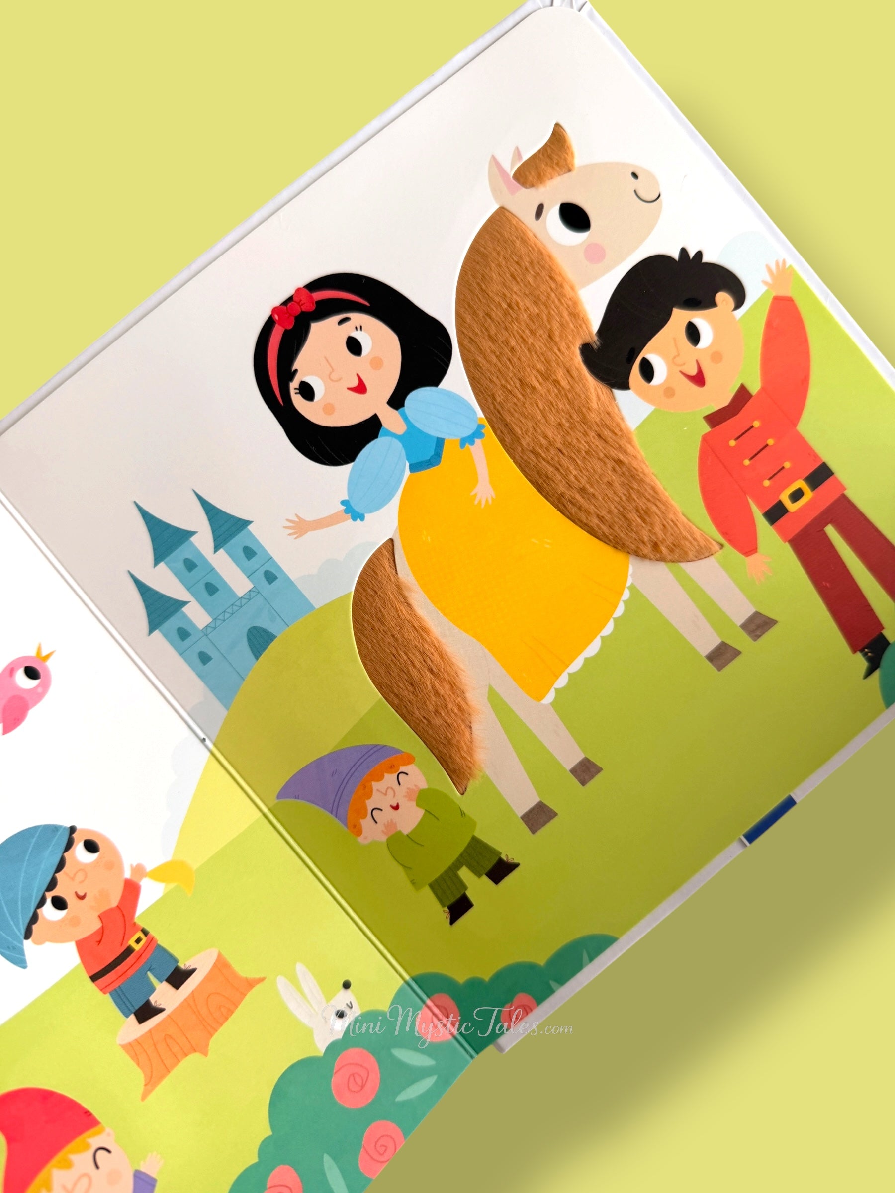 Snow White touch and feel book page showing Snow White riding a horse with prince and dwarfs nearby