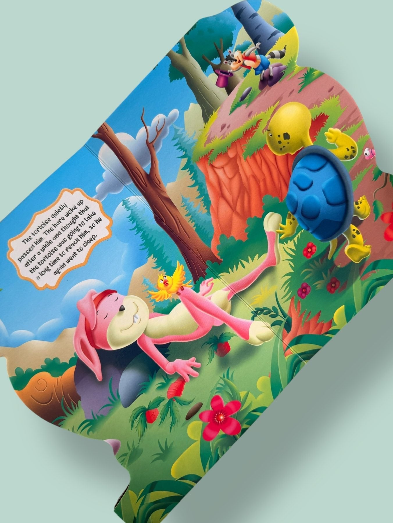 Colourful story pages of The Hare and the Tortoise Story Board Book featuring the hare sleeping while the tortoise steadily continues the race
