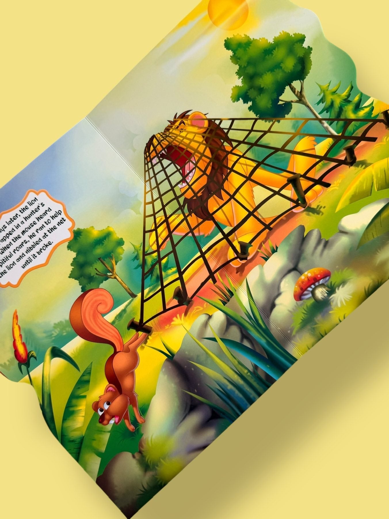 Colourful story pages of The Lion and the Mouse Story Board Book featuring the lion trapped in a hunter’s net and waiting for help